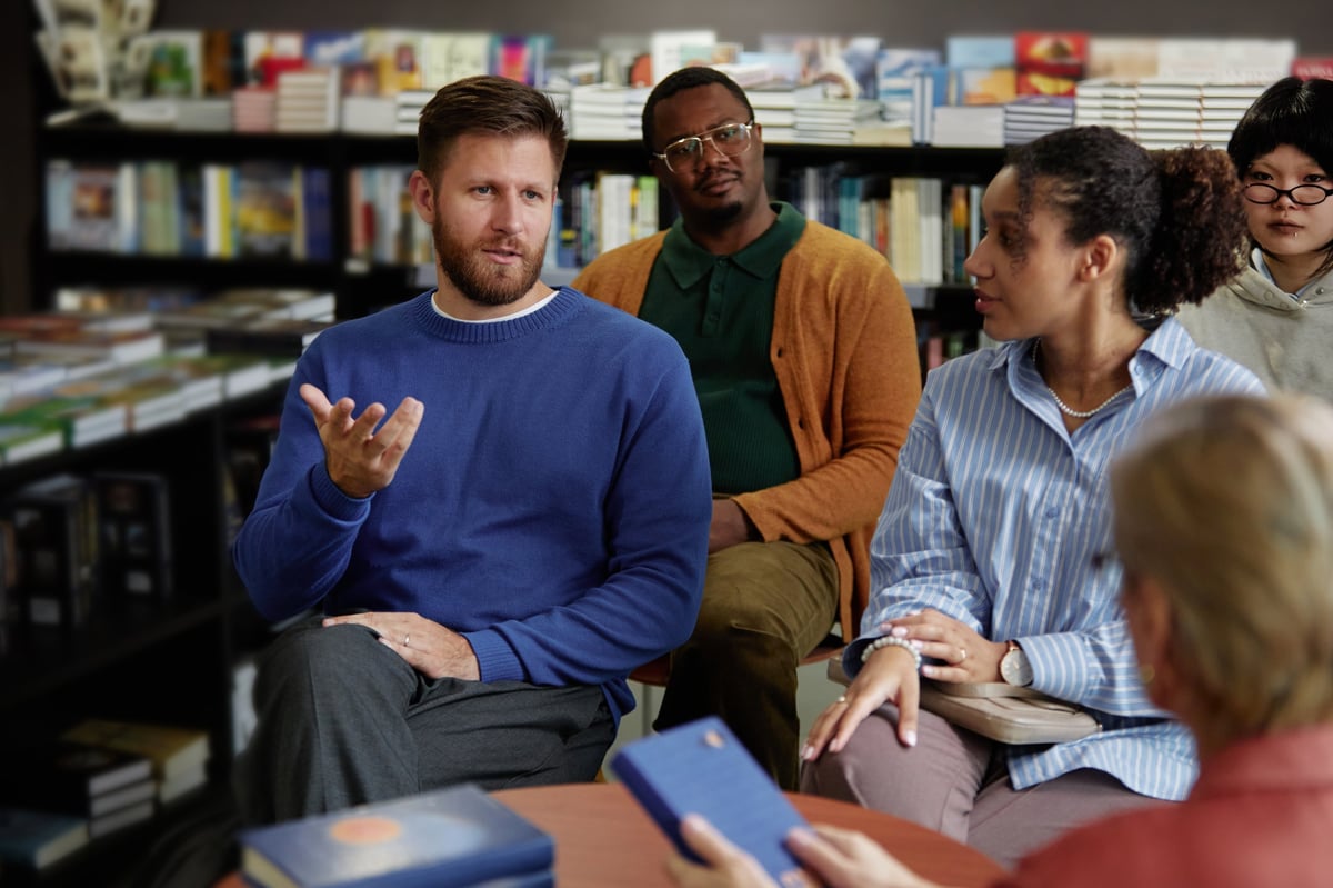 Diverse group engaged in thoughtful discussion in a community bookstore setting