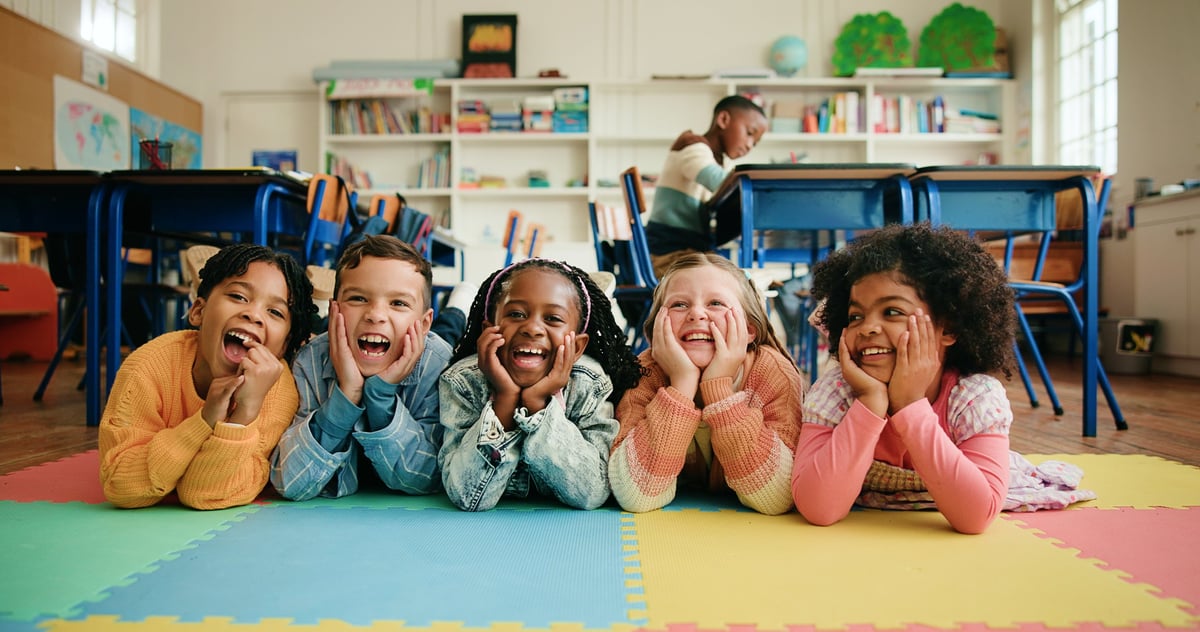 Diverse group of smiling elementary students in a school hallway