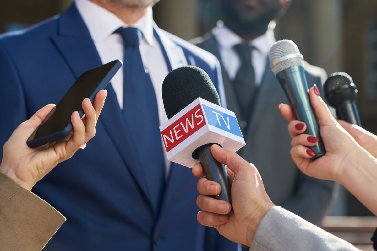 Confident school superintendent speaking to journalists during an outdoor press conference