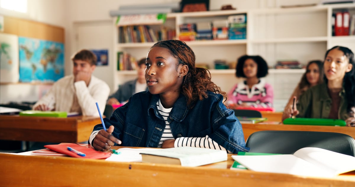 Engaged high school student taking notes in a modern classroom