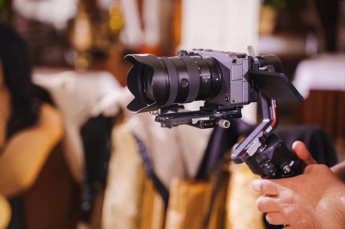 Videographer filming with a professional gimbal camera in a vibrant setting